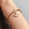 Dreifacher Dangle Charm mit Flugzeug, Globus und Koffer, 14 Karat Roségold-Beschichtung Dreifacher Dangle Charm mit Flugzeug, Globus und Koffer, 14 Karat Roségold-Beschichtung